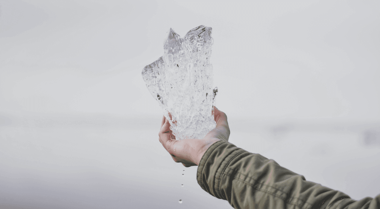 Person holding a melting block of ice