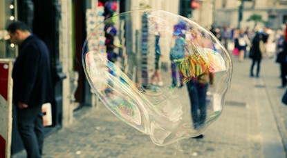 Giant bubble floating on a busy street