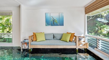 Modern looking lounge in a house, flooded under about a foot of water.