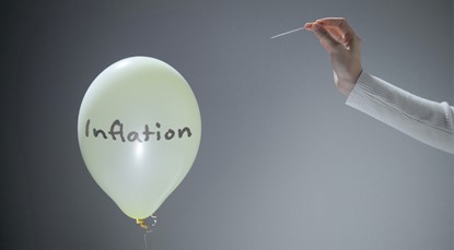 Woman holding a needle up to pop a yellow balloon with the word 'Inflation' on it