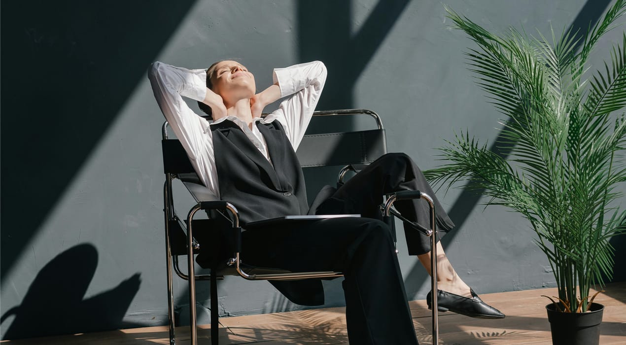 Woman in business attire relaxing in a chair in the sun