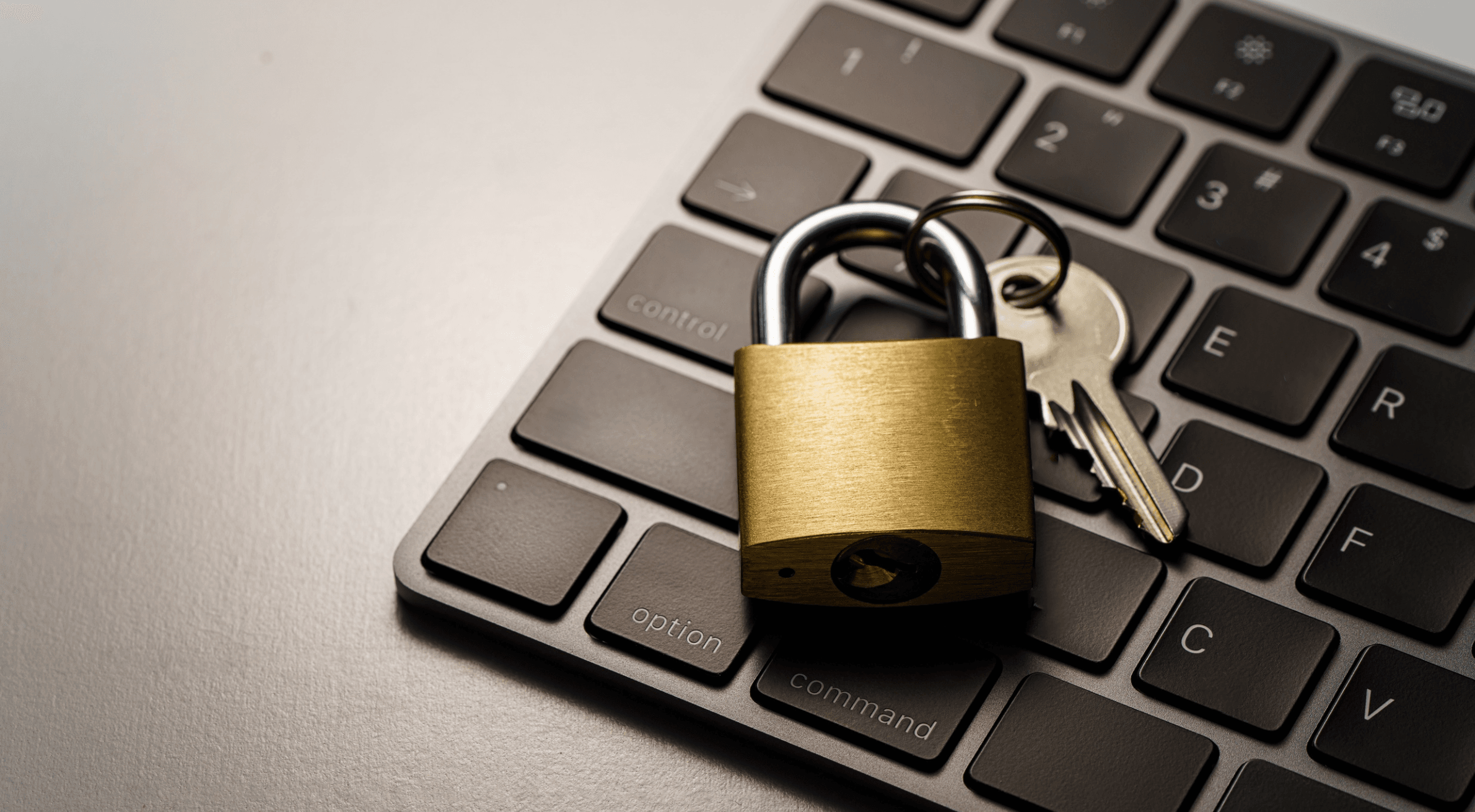 Lock and key sitting on top of a computer keyboard